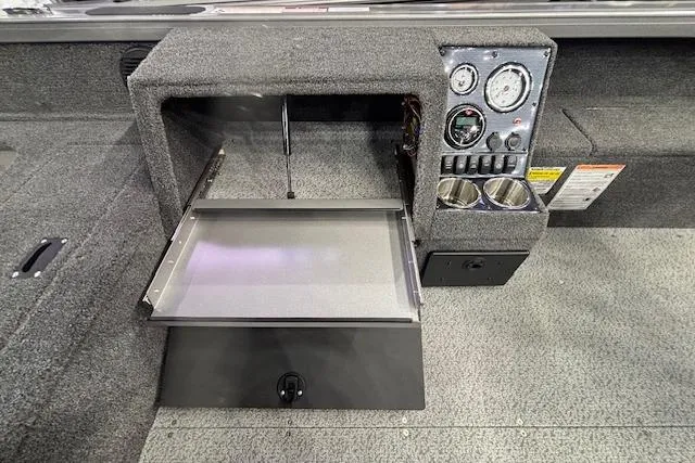 Slide: The Image of Interior of 2026 Crestliner 1850 Pro Tiller boat with control panel and storage compartment. - 22