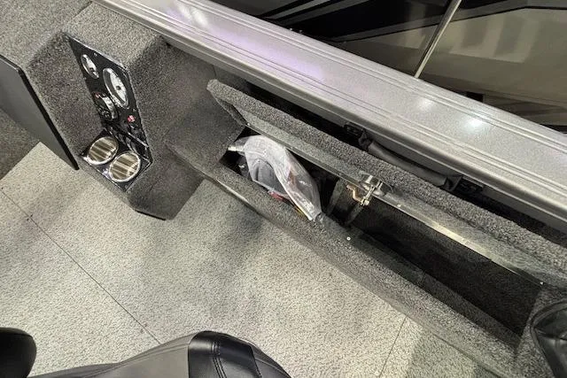 Slide: The Image of 2026 Crestliner 1850 Pro Tiller interior with storage compartment and control panel. - 7