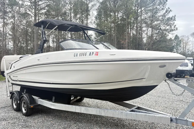 Slide: The Image of 2022 Bayliner VR6 Bowrider OB on trailer, parked outdoors with trees in background. - 4