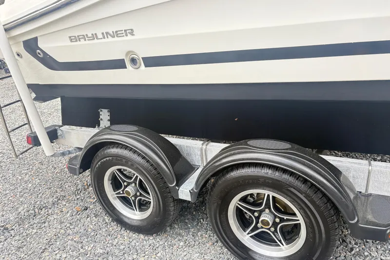 Slide: The Image of 2022 Bayliner VR6 Bowrider OB on trailer with dual wheels, gravel background. - 5