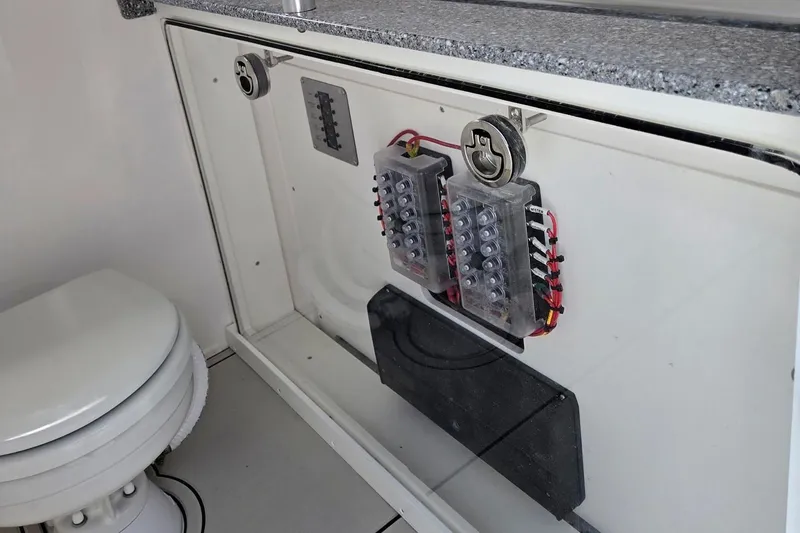 Slide: The Image of Electrical panel and toilet inside 2026 Twin Vee 280 GFX2 CC boat cabin. - 10
