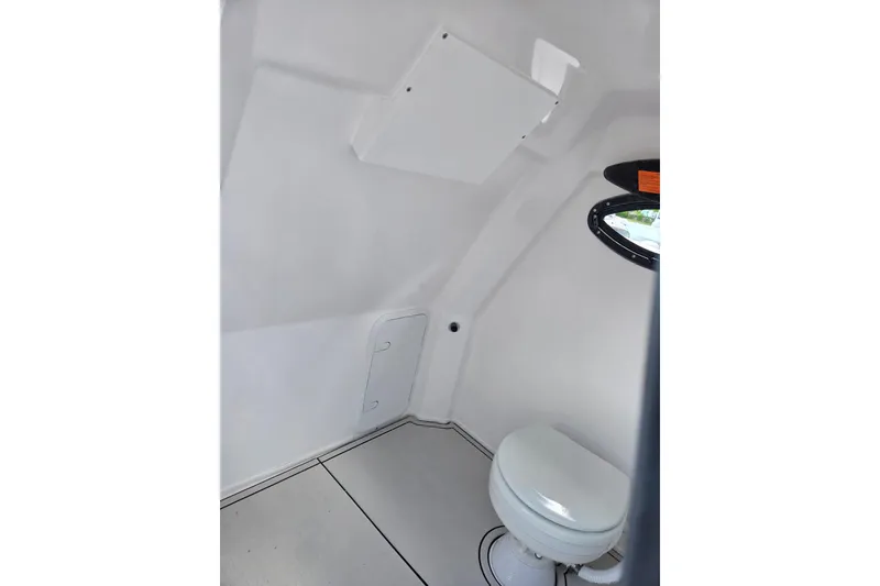 Slide: The Image of Interior of 2026 Twin Vee 280 GFX2 CC boat featuring a compact marine toilet. - 11
