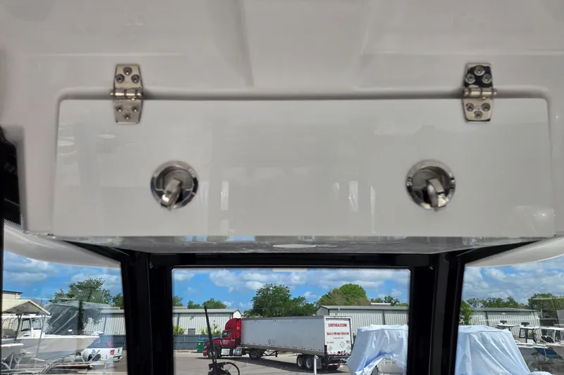 Slide: The Image of 2026 Twin Vee 280 GFX2 CC boat interior with storage compartment and latch details. - 18