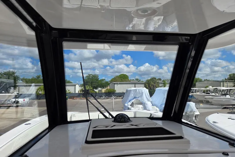 Slide: The Image of Interior view from a 2026 Twin Vee 280 GFX2 CC boat, showcasing marina and sky. - 21