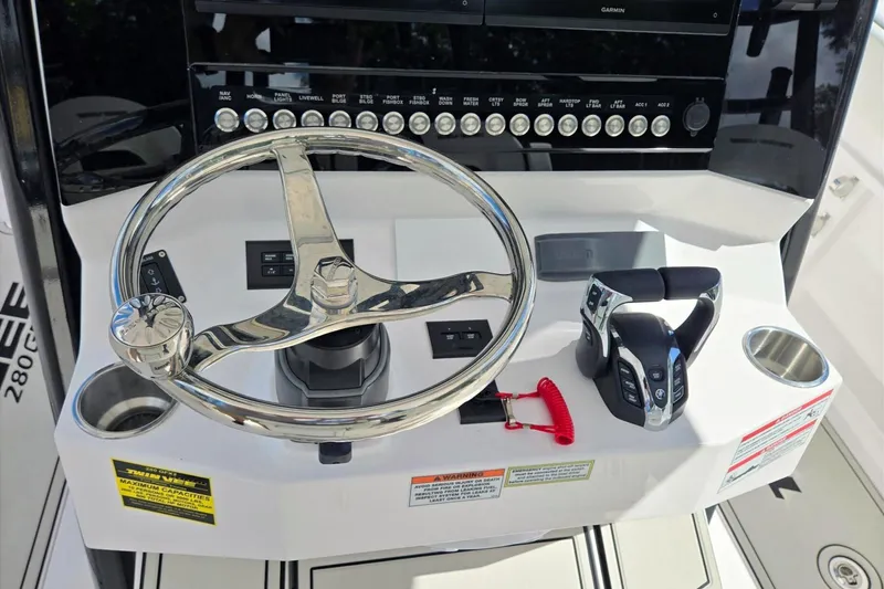Slide: The Image of 2026 Twin Vee 280 GFX2 CC boat dashboard with steering wheel and controls. - 22