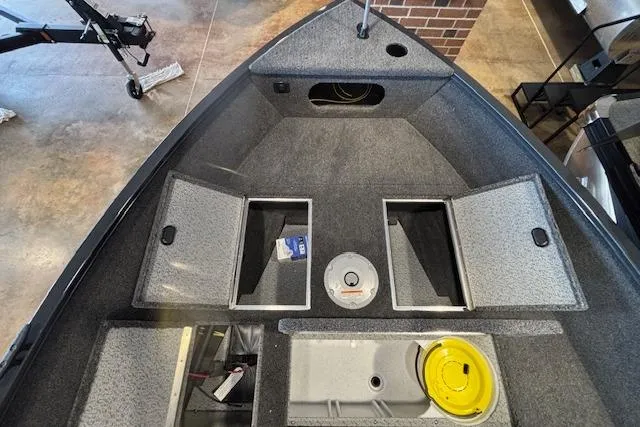 Slide: The Image of 2026 Crestliner 1650 Kodiak Tiller boat interior with storage compartments and fishing gear. - 4