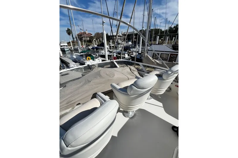 Slide: The Image of 1999 Sea Ray 400 Sedan Bridge yacht with white seating, docked at a marina. - 10