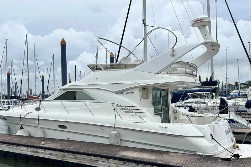 Slide: The Image of 1999 Sea Ray 400 Sedan Bridge yacht docked at marina, surrounded by sailboats. - 11