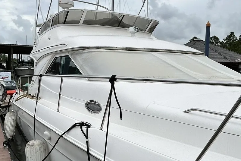 Slide: The Image of 1999 Sea Ray 400 Sedan Bridge yacht docked at marina under cloudy skies. - 14
