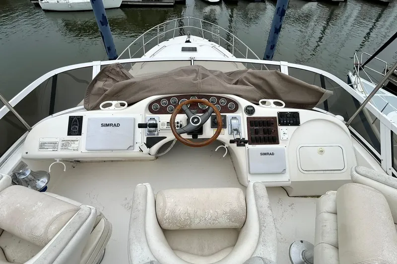 Slide: The Image of 1999 Sea Ray 400 Sedan Bridge helm with steering wheel and navigation equipment. - 16