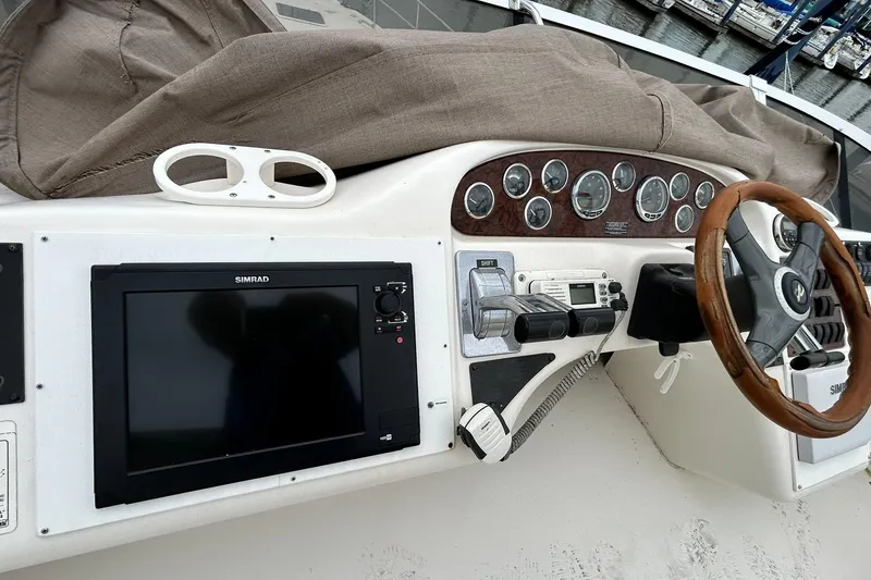 Slide: The Image of 1999 Sea Ray 400 Sedan Bridge helm with Simrad display and wooden steering wheel. - 17