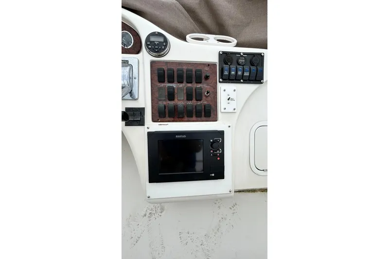 Slide: The Image of Control panel of a 1999 Sea Ray 400 Sedan Bridge boat with switches and navigation display. - 19