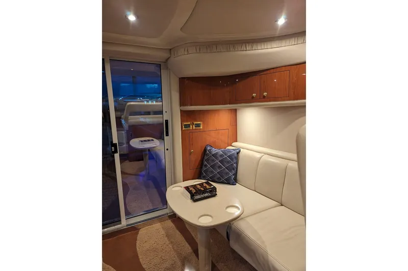 Slide: The Image of Interior of 1999 Sea Ray 400 Sedan Bridge with cozy seating and elegant wood cabinetry. - 2