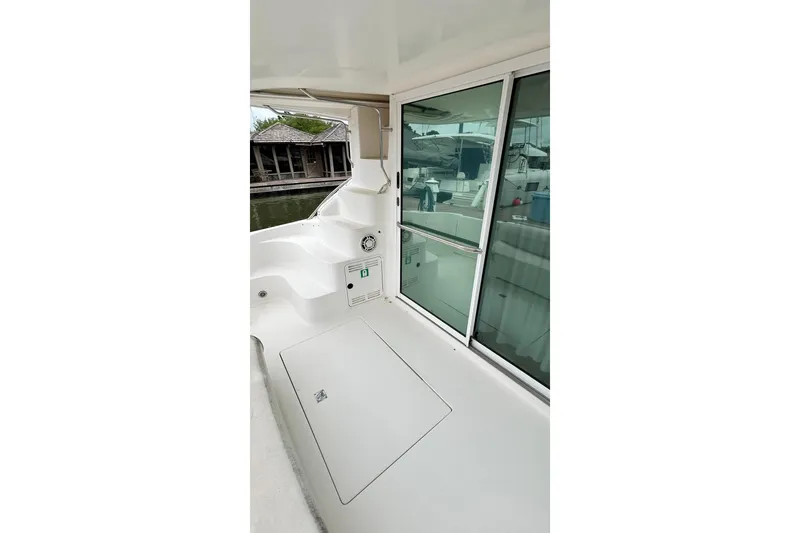 Slide: The Image of 1999 Sea Ray 400 Sedan Bridge yacht deck with sliding glass door and marina view. - 21