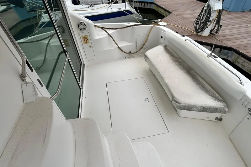 Slide: The Image of 1999 Sea Ray 400 Sedan Bridge boat interior with seating and dock view. - 22