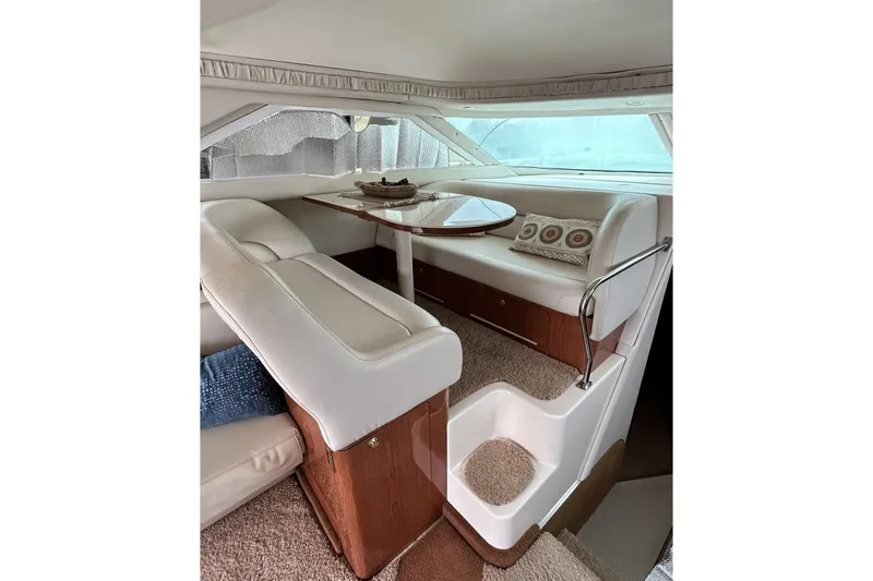 Slide: The Image of Luxurious interior of a 1999 Sea Ray 400 Sedan Bridge yacht with elegant seating and table. - 26