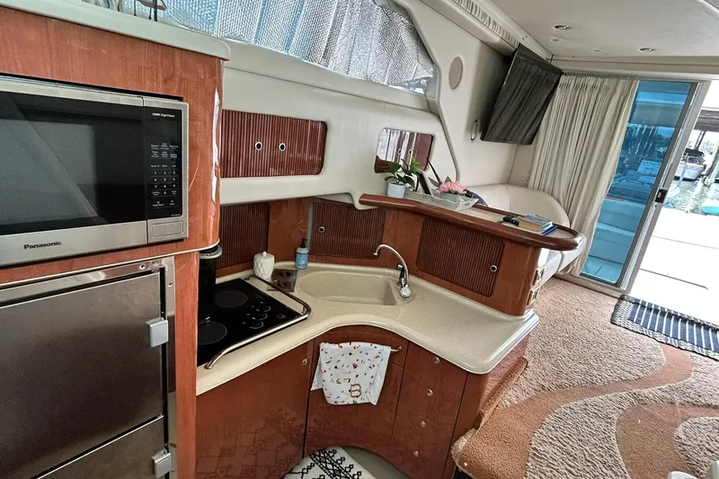 Slide: The Image of Interior of a 1999 Sea Ray 400 Sedan Bridge yacht with kitchen and lounge area. - 29