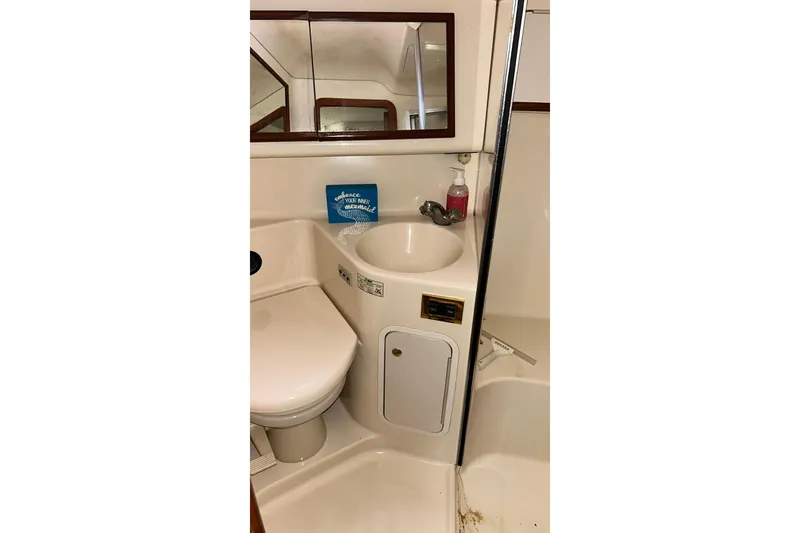 Slide: The Image of 1999 Sea Ray 400 Sedan Bridge bathroom with sink, toilet, and mirror. - 38