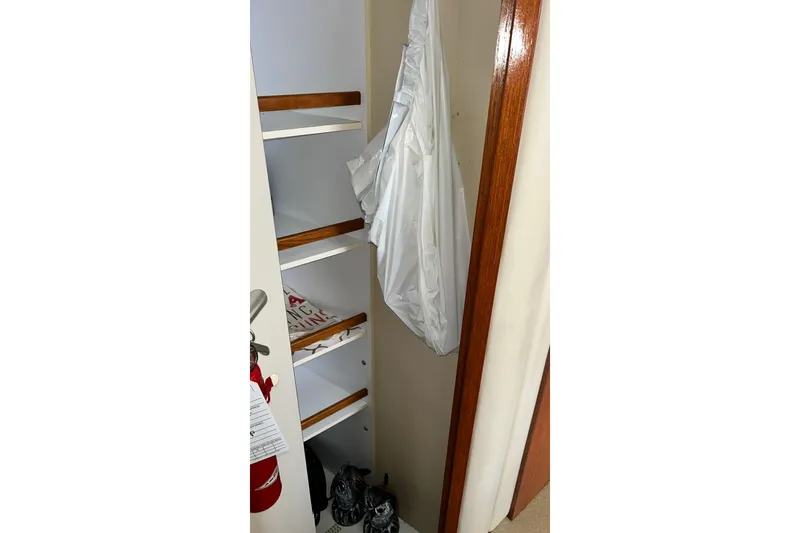 Slide: The Image of Storage shelves inside a 1999 Sea Ray 400 Sedan Bridge boat, featuring wooden accents. - 42