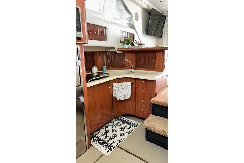 Slide: The Image of Interior of 1999 Sea Ray 400 Sedan Bridge yacht kitchen with wood cabinetry and modern amenities. - 43