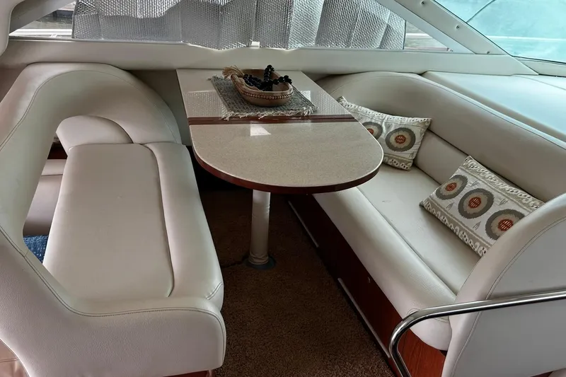 Slide: The Image of Interior of 1999 Sea Ray 400 Sedan Bridge with dining area and cushioned seating. - 45