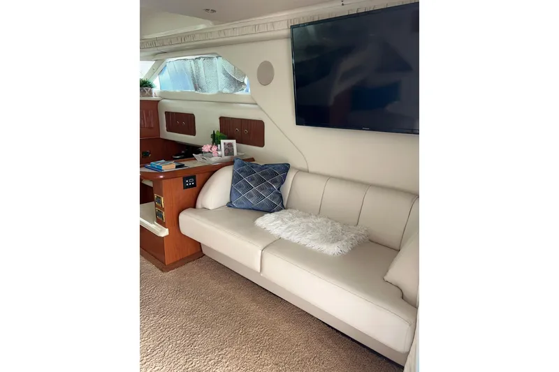 Slide: The Image of Interior of 1999 Sea Ray 400 Sedan Bridge with beige sofa and wall-mounted TV. - 47