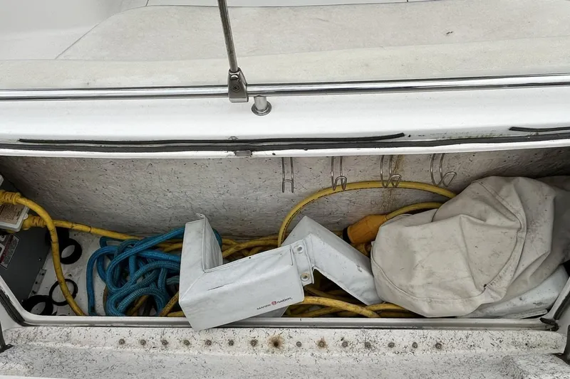 Slide: The Image of Storage compartment on a 1999 Sea Ray 400 Sedan Bridge with ropes and equipment. - 49