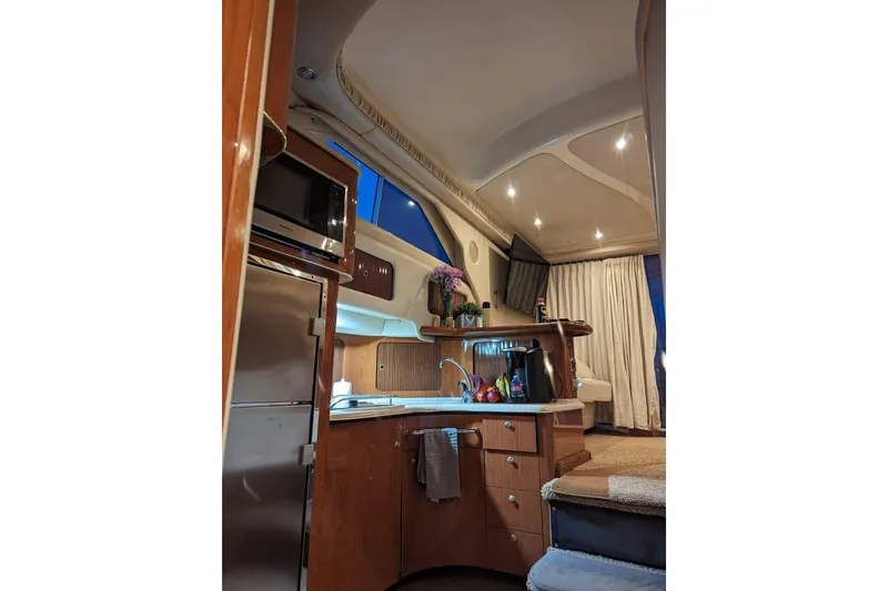 Slide: The Image of Interior of a 1999 Sea Ray 400 Sedan Bridge yacht, featuring a cozy kitchen area. - 5