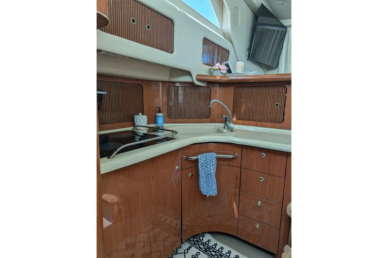 Slide: The Image of 1999 Sea Ray 400 Sedan Bridge kitchen with wood cabinets and modern amenities. - 7