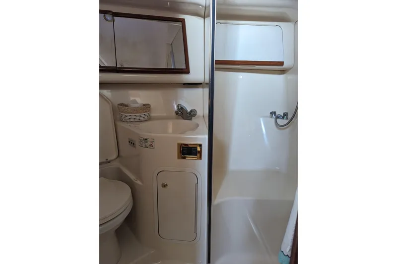 Slide: The Image of Bathroom interior of 1999 Sea Ray 400 Sedan Bridge yacht, featuring sink and shower. - 9