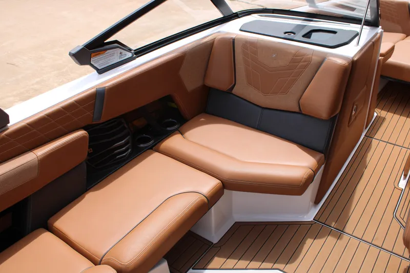 Slide: The Image of 2021 Nautique Super Air Nautique G25 interior with luxurious brown seating and sleek design. - 10