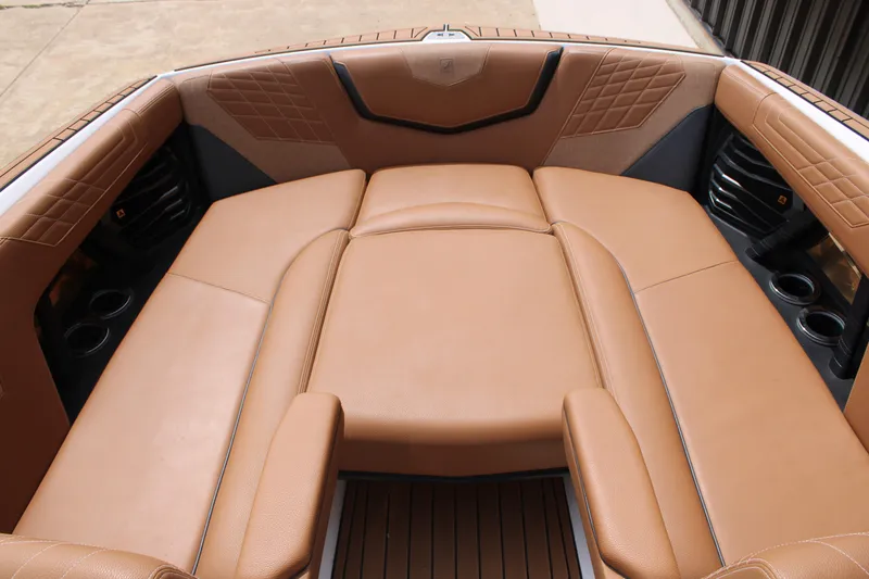 Slide: The Image of Luxurious tan seating in 2021 Nautique Super Air Nautique G25 boat interior. - 15
