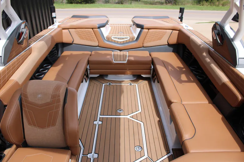 Slide: The Image of 2021 Nautique Super Air Nautique G25 interior with luxurious tan seating and teak flooring. - 16