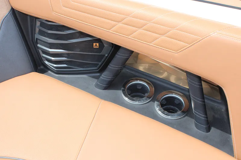 Slide: The Image of 2021 Nautique Super Air Nautique G25 interior with tan leather and cup holders. - 17
