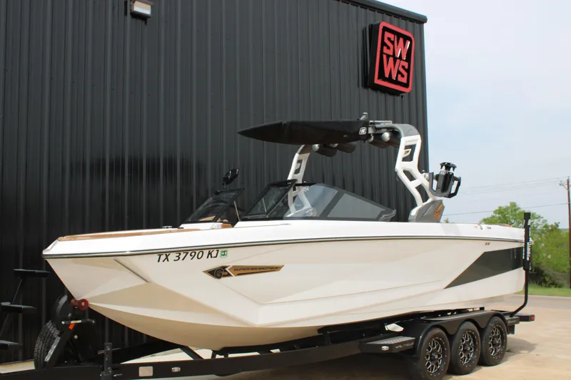 Slide: The Image of 2021 Nautique Super Air Nautique G25 boat on trailer outside SWWS building. - 2