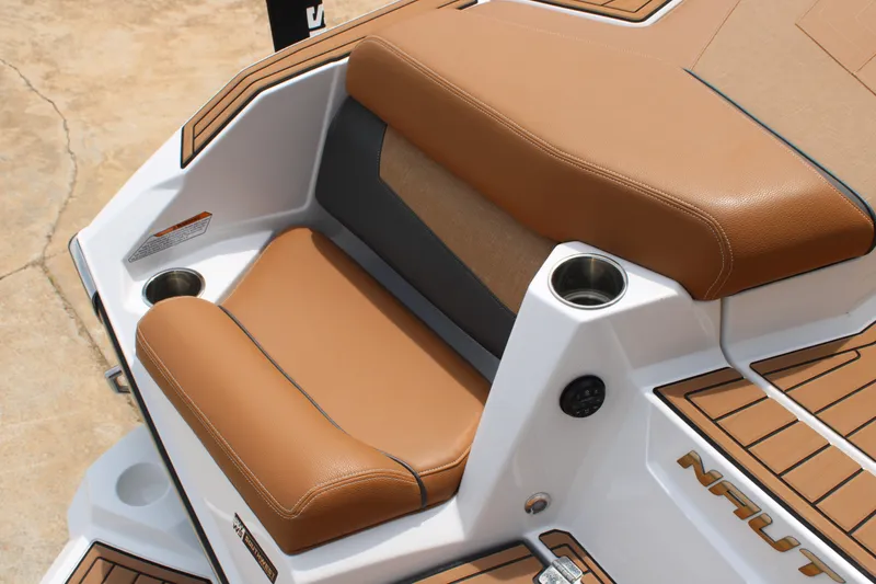 Slide: The Image of 2021 Nautique Super Air Nautique G25 boat seat with tan upholstery and cup holder. - 7
