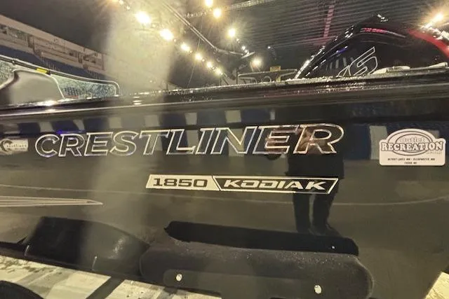 Slide: The Image of 2026 Crestliner 1850 Kodiak WT boat under bright lights at an indoor event. - 3