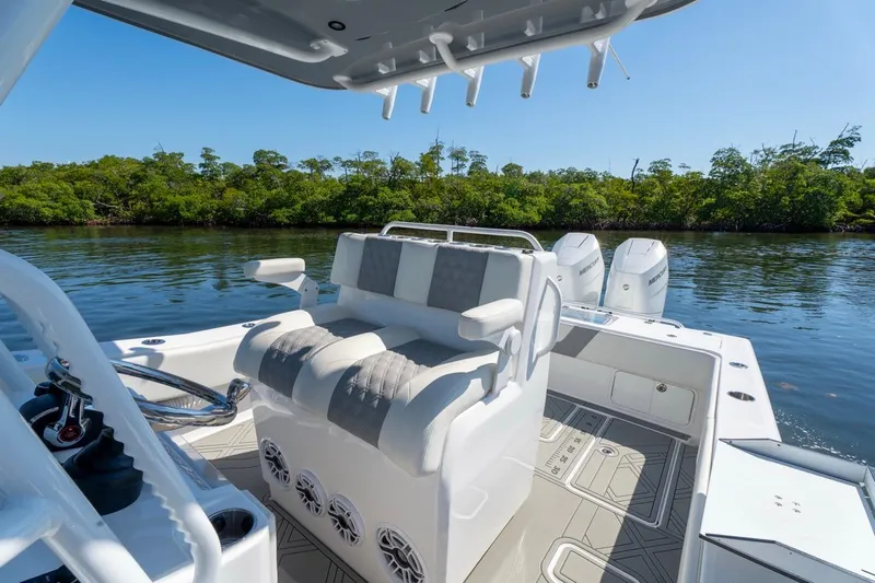 Slide: The Image of 2025 Invincible 33 Open Fisherman boat interior with seating and dual engines on calm water. - 10