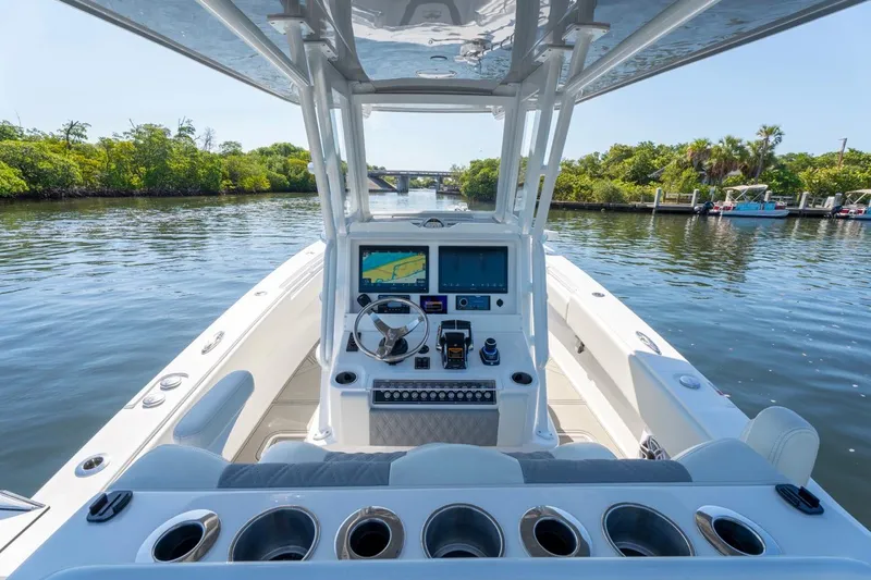 Slide: The Image of 2025 Invincible 33 Open Fisherman boat interior with advanced navigation system on calm waterway. - 8