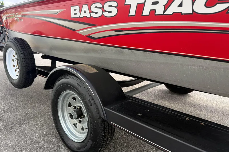 Slide: The Image of 2007 Tracker Pro Team 175 TXW boat trailer, red with bold graphics, parked on pavement. - 7