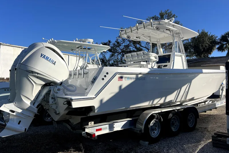The Image of 2026 Contender 32 ST boat with Yamaha engines on a trailer, under clear blue sky. - 0