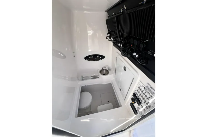 Slide: The Image of Interior of 2026 Contender 32 ST boat featuring a compact bathroom and control panel. - 10