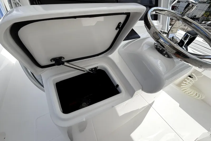 Slide: The Image of Open storage compartment and steering wheel on 2026 Contender 32 ST boat. - 14