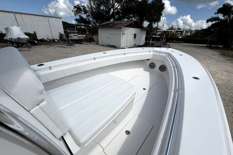 Slide: The Image of 2026 Contender 32 ST boat with white seating and spacious deck in a marina setting. - 17
