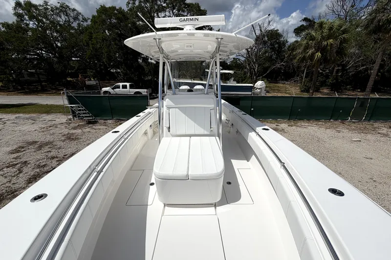 Slide: The Image of 2026 Contender 32 ST boat with white seating and Garmin equipment, parked outdoors. - 19