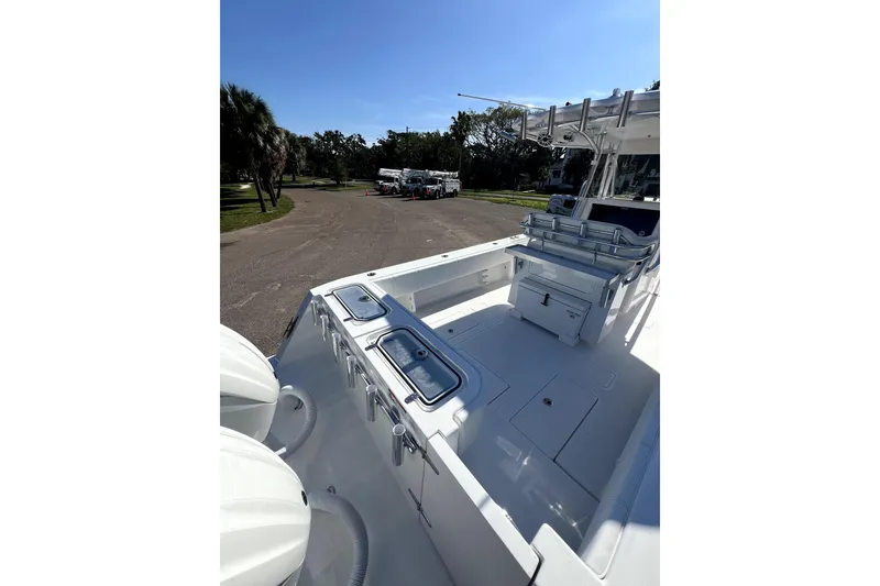 Slide: The Image of 2026 Contender 32 ST boat interior with seating and storage, parked outdoors. - 2