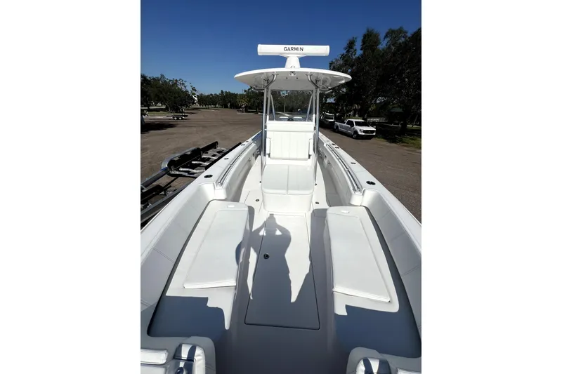 Slide: The Image of 2026 Contender 32 ST boat interior with seating and Garmin equipment, parked outdoors. - 9