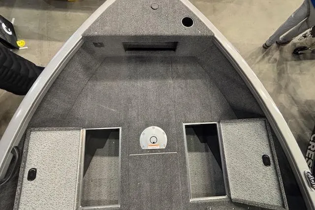 Slide: The Image of 2026 Crestliner 1650 Hawk boat interior with storage compartments and carpeted flooring. - 12
