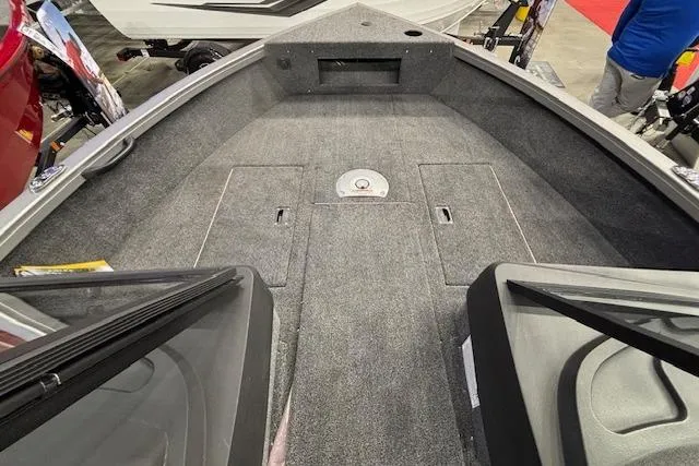 Slide: The Image of 2026 Crestliner 1650 Hawk boat interior with carpeted deck and storage compartments. - 13