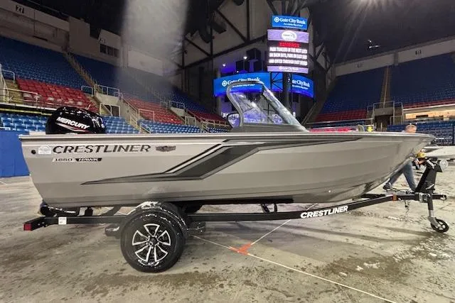 Slide: The Image of 2026 Crestliner 1650 Hawk boat on display in an indoor arena setting. - 2